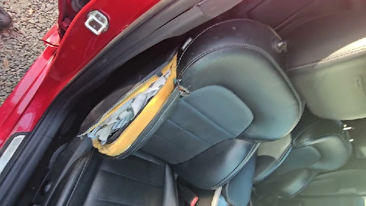 Damaged car seat with exposed padding inside.