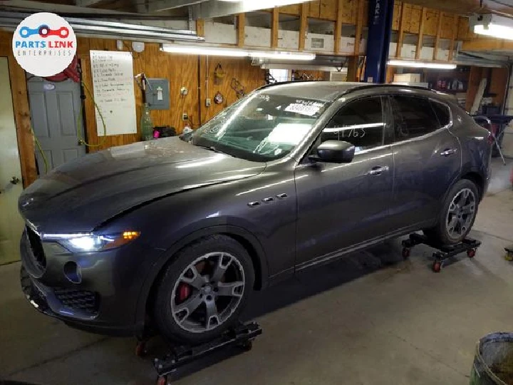 Gray SUV on lifts in a workshop setting.