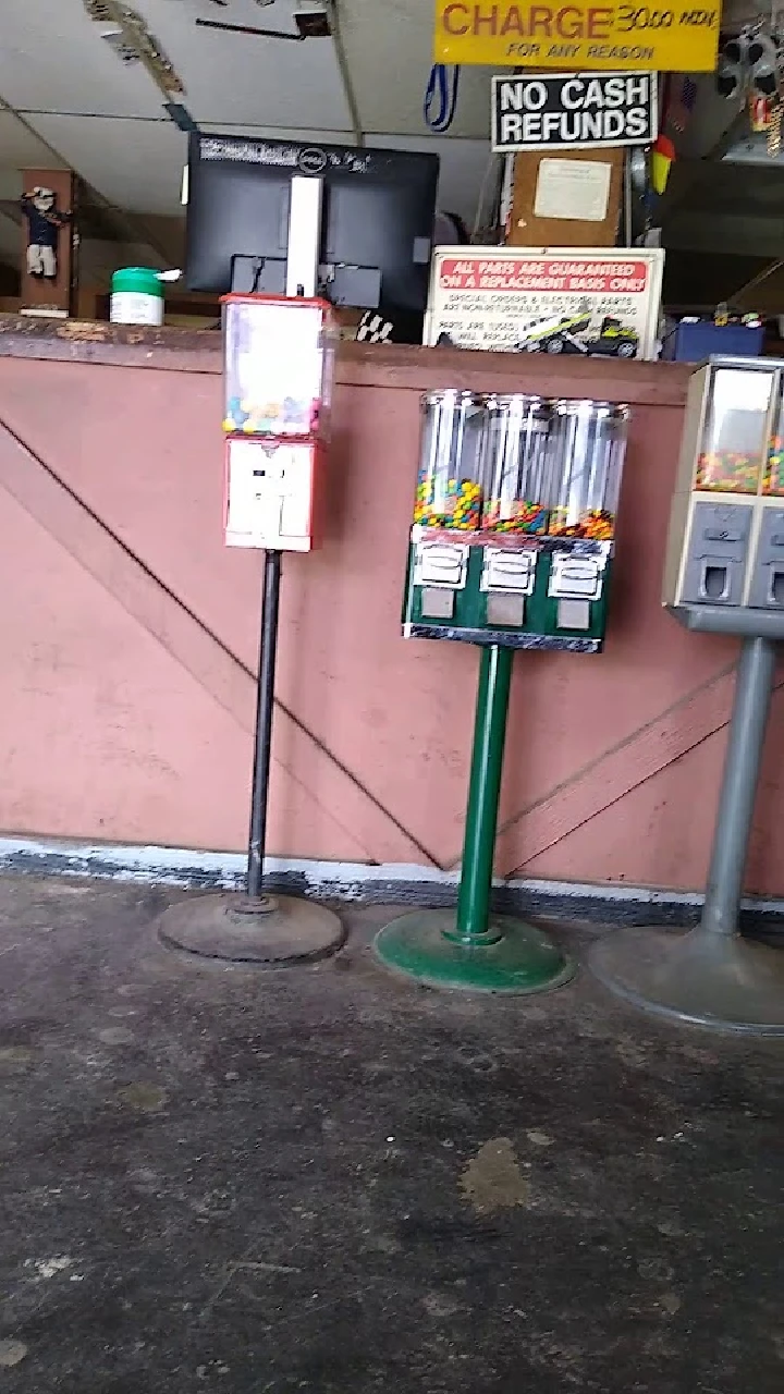 Gumball and candy vending machines in a shop.