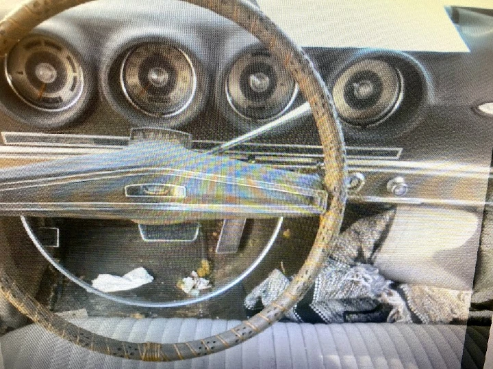 Interior of an old car with a worn steering wheel.