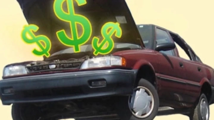 Junk car with dollar signs above it.