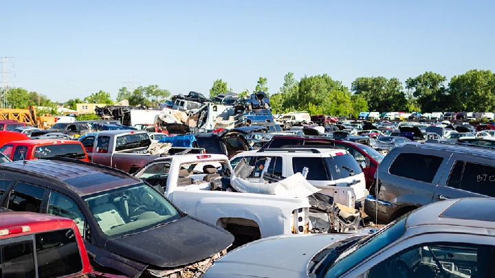 Junkyard filled with various discarded vehicles.