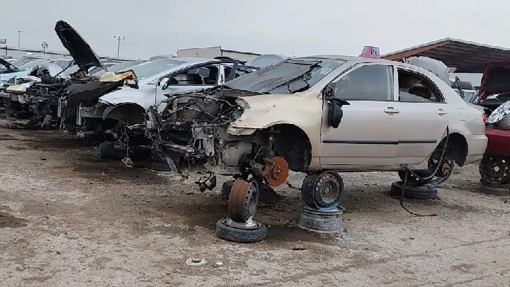 Junkyard scene with disassembled cars on display.