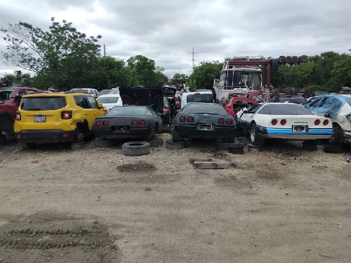 Junkyard scene with various salvaged vehicles.