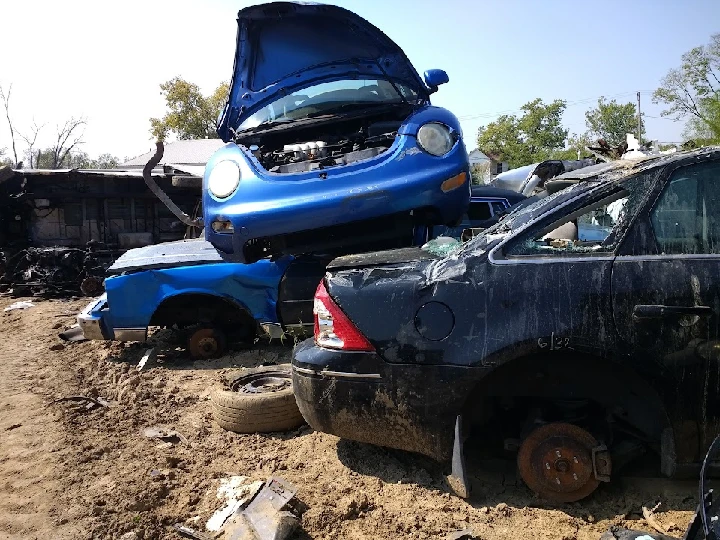 Junkyard with stacked abandoned vehicles.