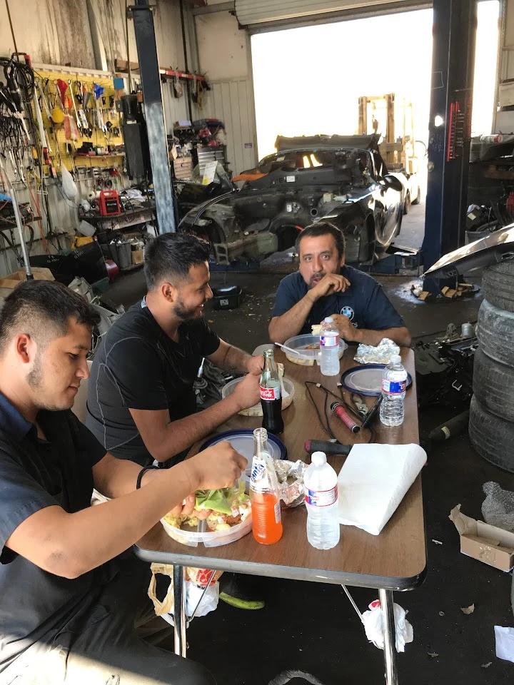 Mechanics enjoying lunch in a workshop setting.