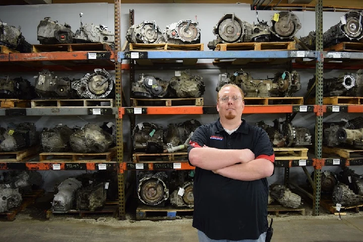 Person standing in front of auto parts shelves.