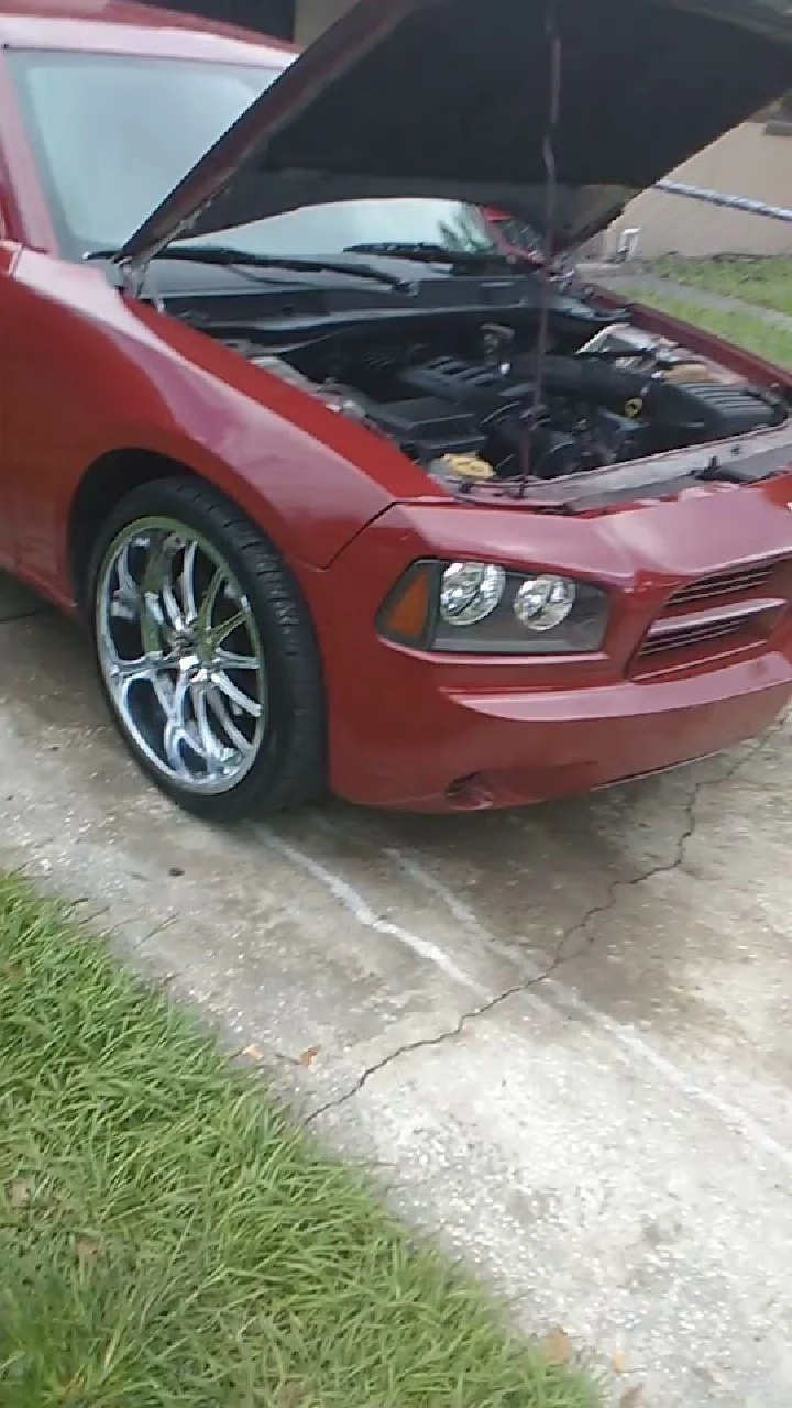 Red car with open hood, showcasing engine area.