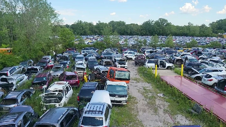 Salvage yard filled with parked junk cars and parts.