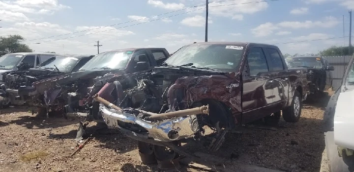 Salvaged trucks in a junkyard under a blue sky.