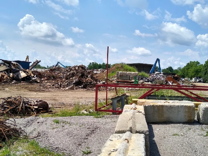 Scrap yard with piles of metal and machinery.