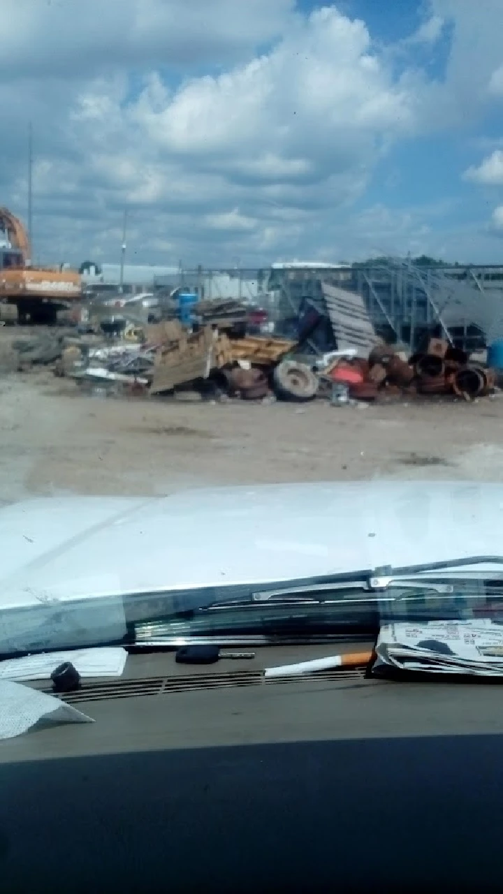 Scrap yard with various materials and equipment.