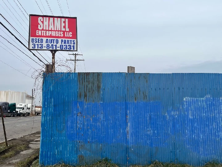 Sign for Shamel Auto Parts on a blue fence.