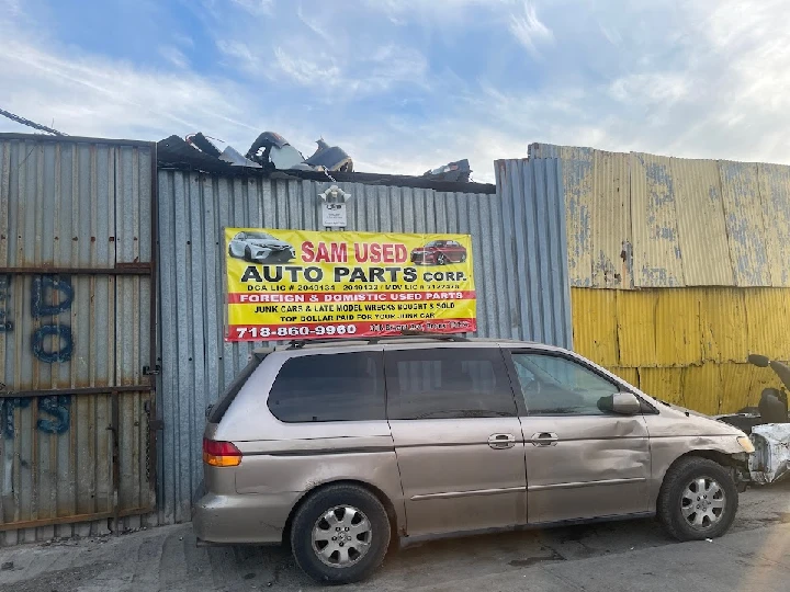 Sign and vehicles at Sam Used Auto Parts location.