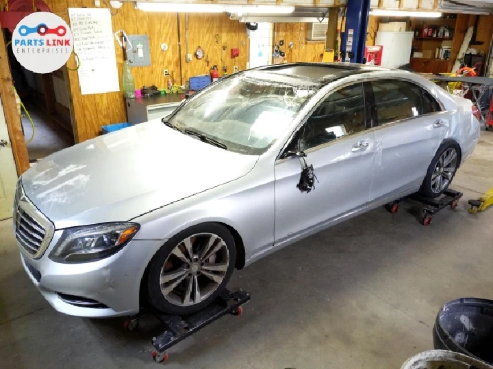 Silver car on repair stands in a workshop.