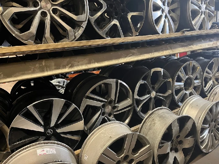 Stack of various auto wheels for sale.