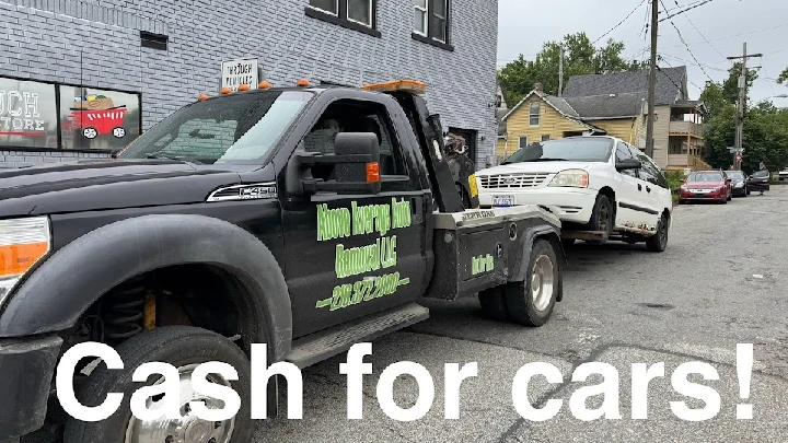 Tow truck removing a white car for cash offer.