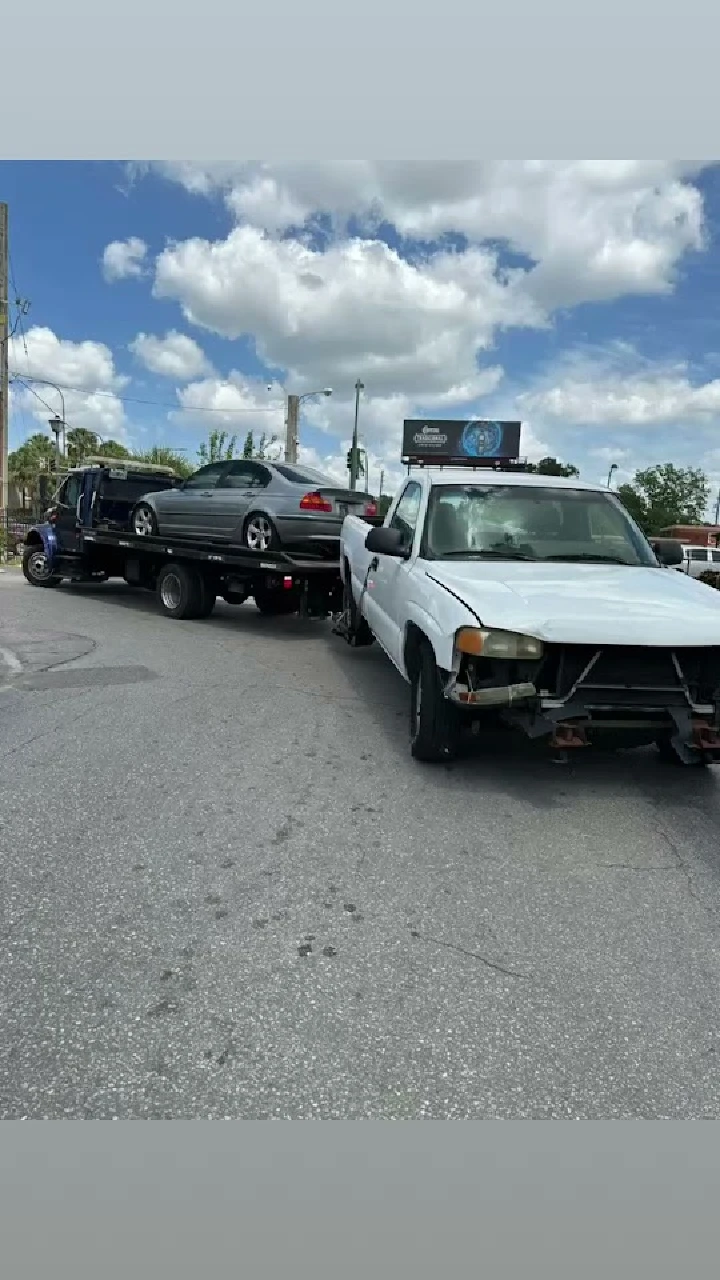 Tow truck transporting junk cars on the road.