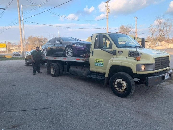 Tow truck with vehicle being loaded for transport.