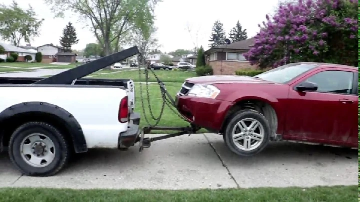 Towing a red car with a white pickup truck.