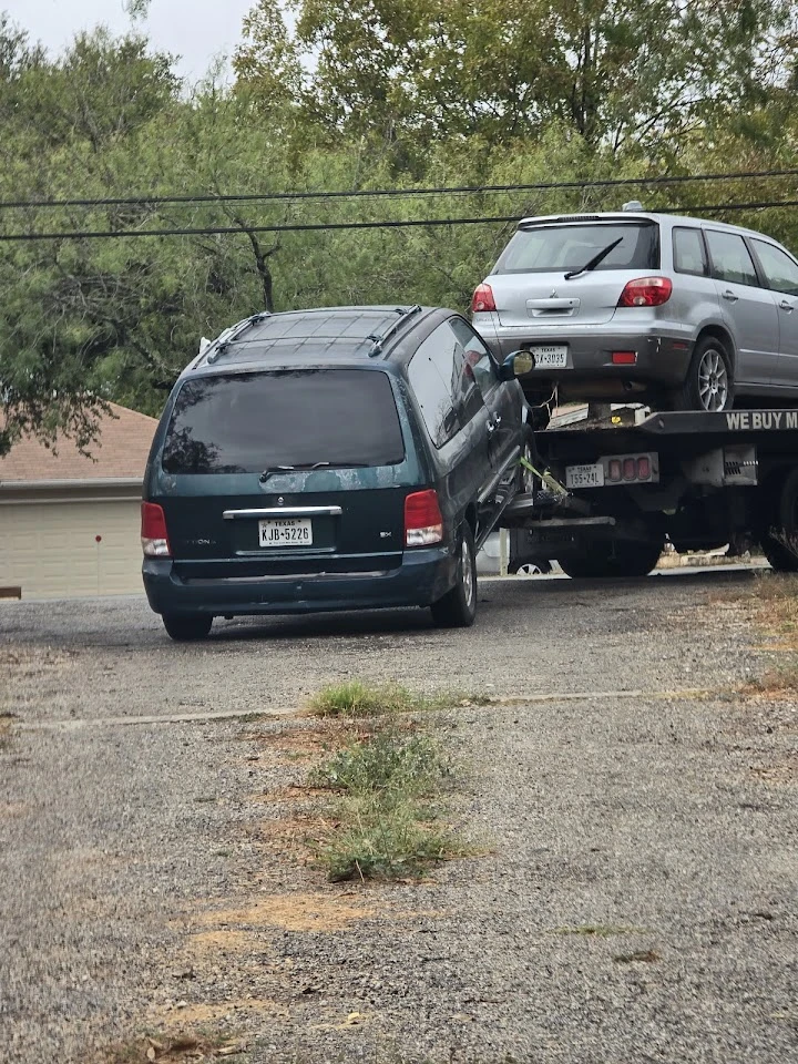 Towing two cars on a flatbed truck.