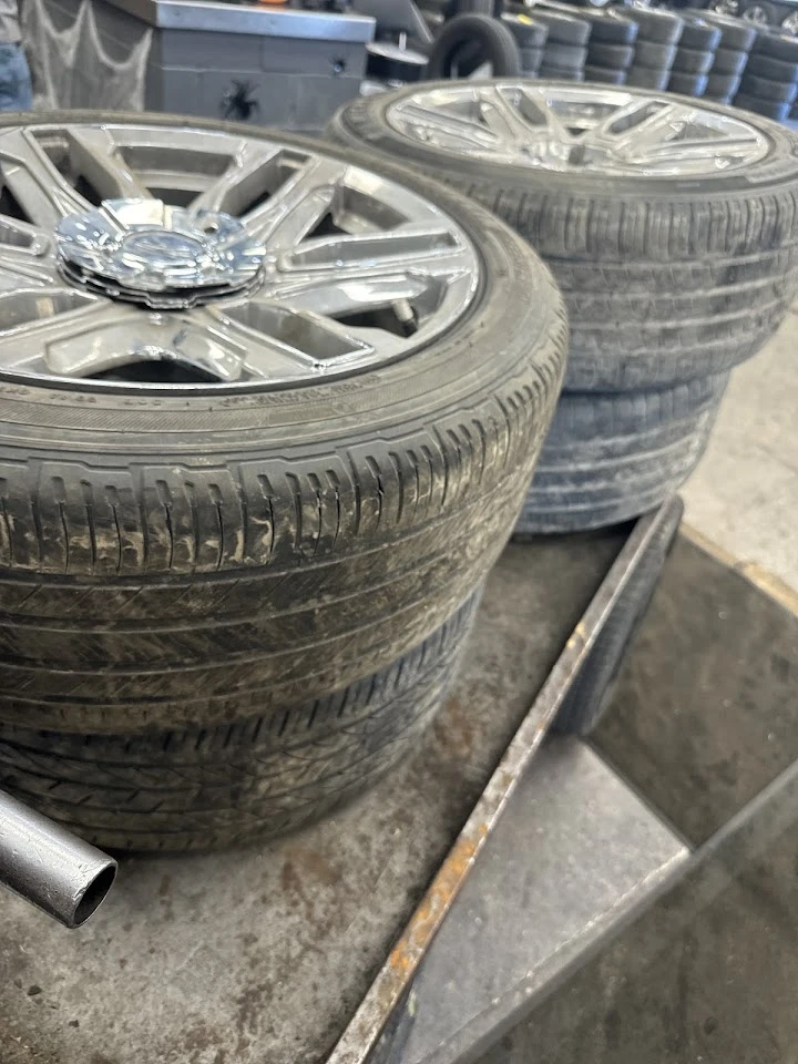 Used tires and wheels on a display rack.