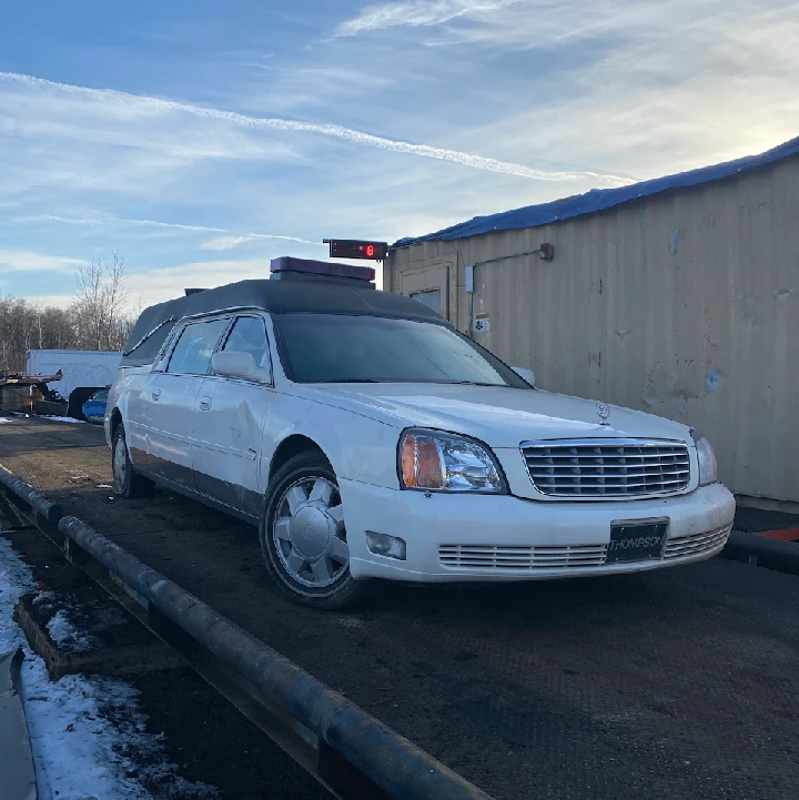 White limousine on a staging area at a recycle facility.