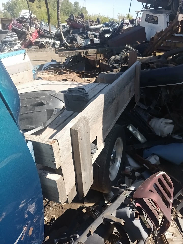 Wooden platform on a vehicle in a junkyard.