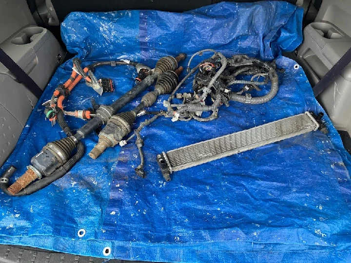 Auto parts displayed on a blue tarp.