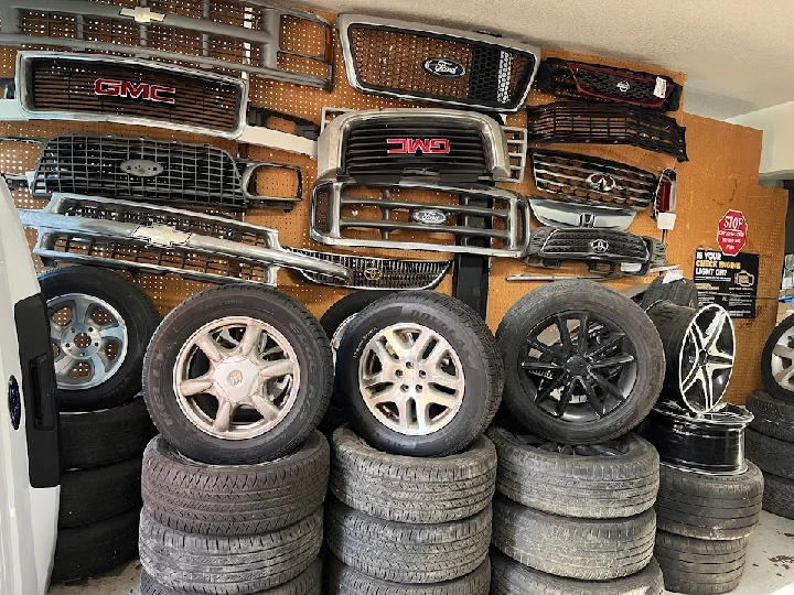 Auto parts displayed on a wall with stacked tires.