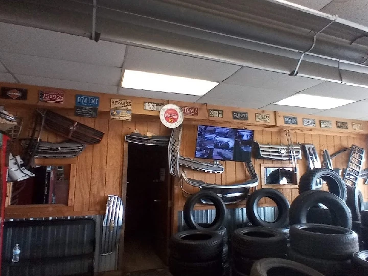 Auto parts displayed on a wooden wall with tires.