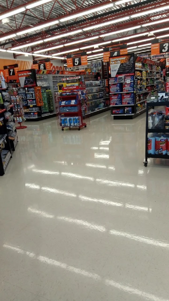 Auto parts store aisle with products and displays.