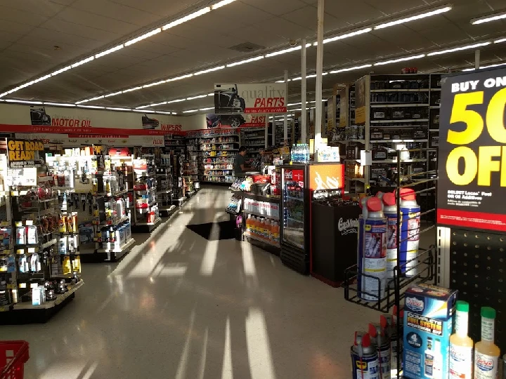 Auto parts store aisle with products and promotions.