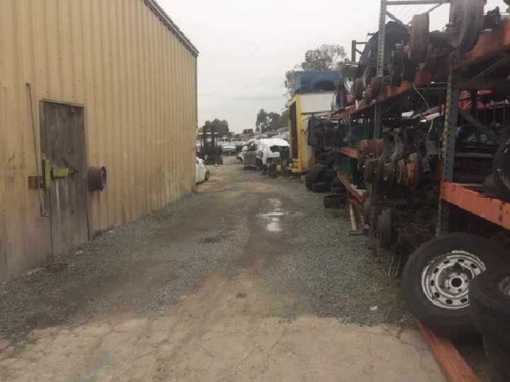 Auto recycling yard with stacked car parts.