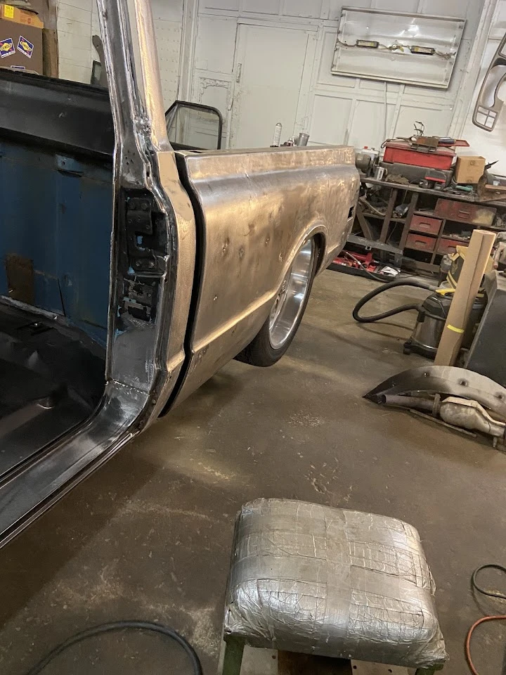 Auto salvage yard with an old truck in repair.