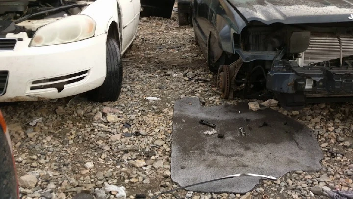 Auto wrecking yard with cars and debris.