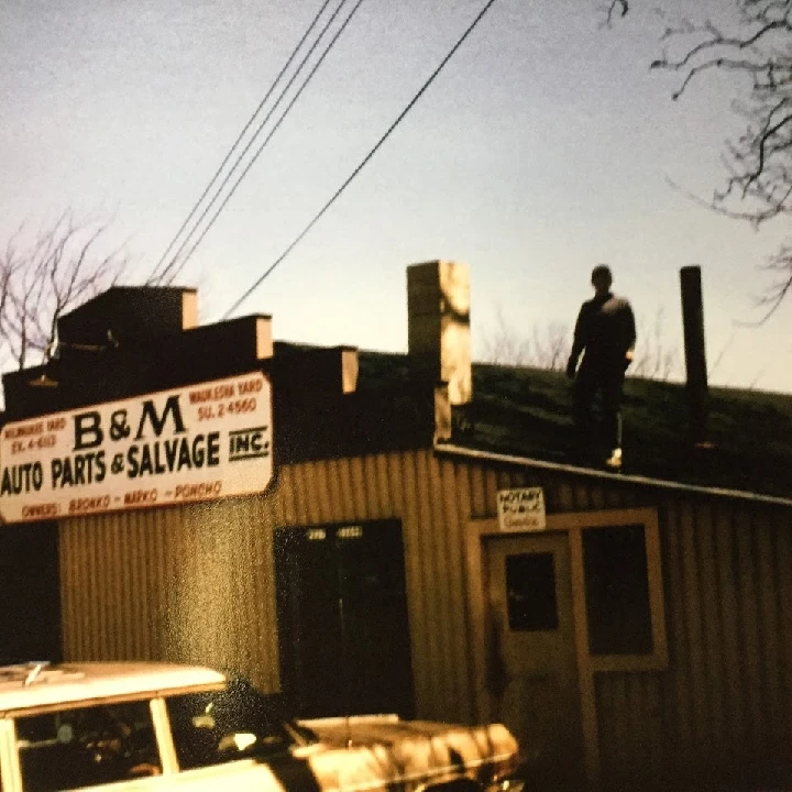 B&M Auto Sales & Parts building with a person on roof.