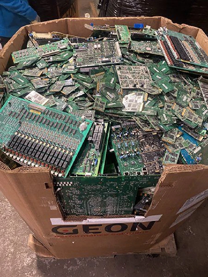 Bin filled with piled electronic circuit boards.