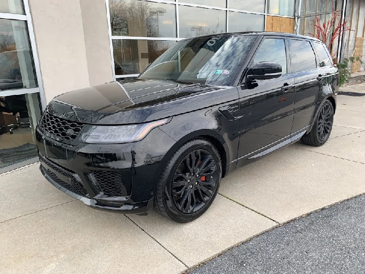 Black luxury SUV parked outside a service center.