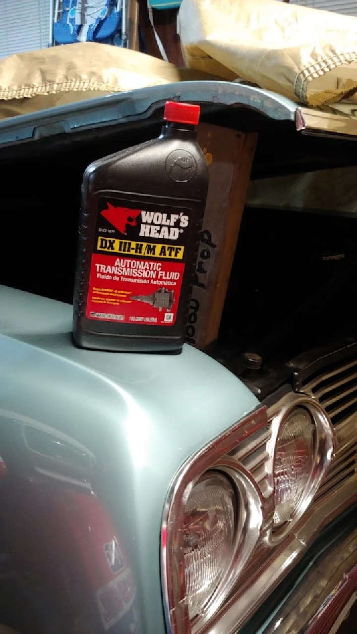 Bottle of transmission fluid on a car hood.