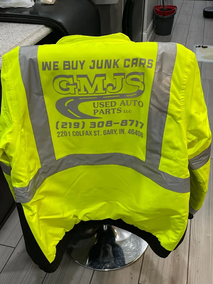 Bright yellow jacket with GMJS Used Auto Parts logo.