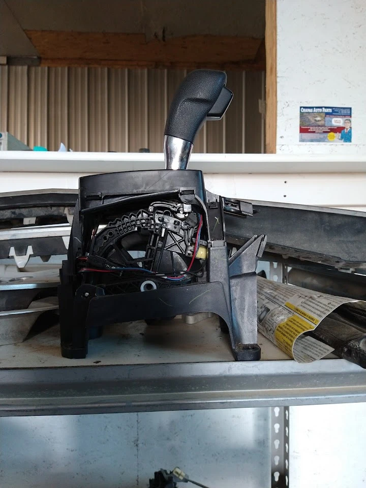 Car gear shift mechanism on a shelf.