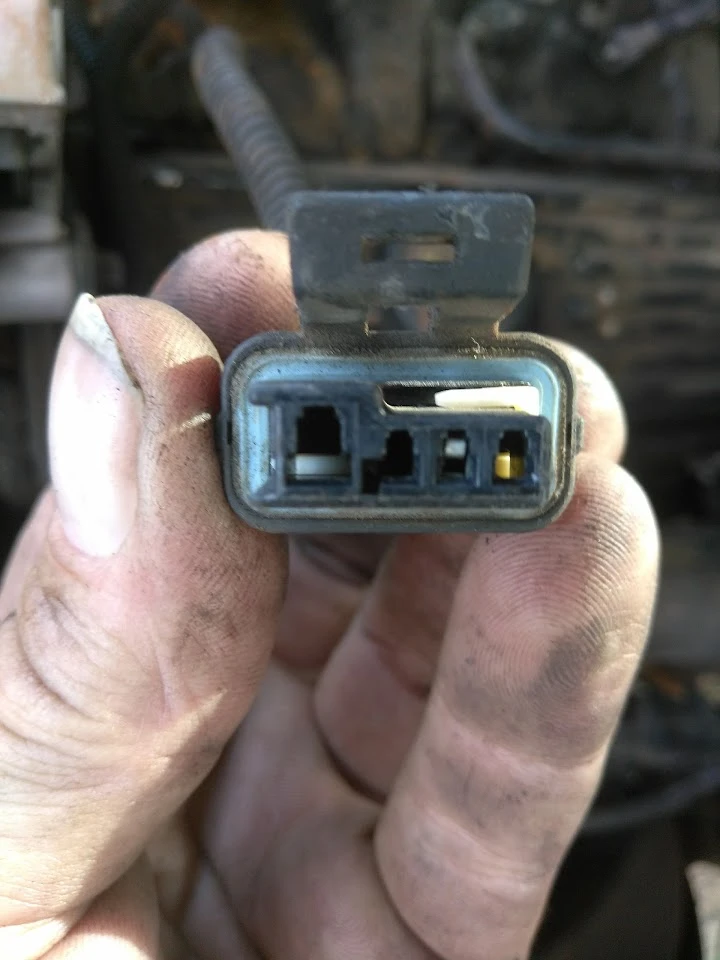 Close-up of a car connector in a hand.