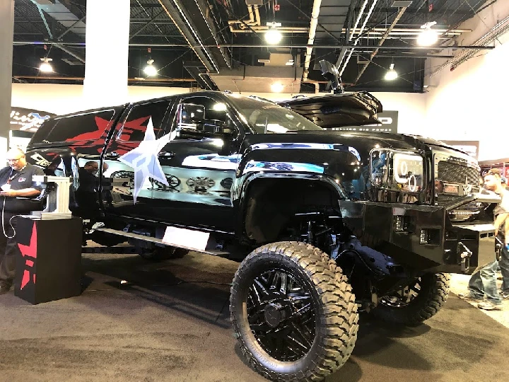 Custom black lifted truck on display at a garage.