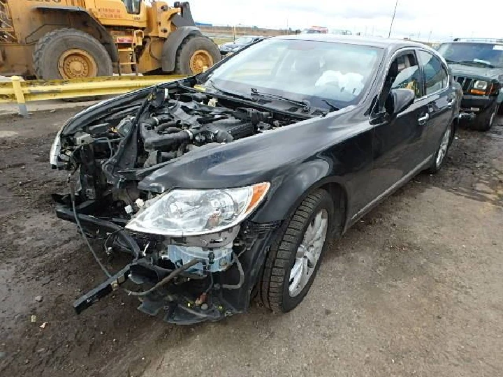 Damaged black sedan with missing front components.