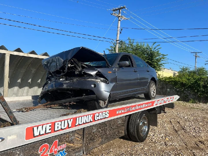 Damaged car on tow truck for recycling.