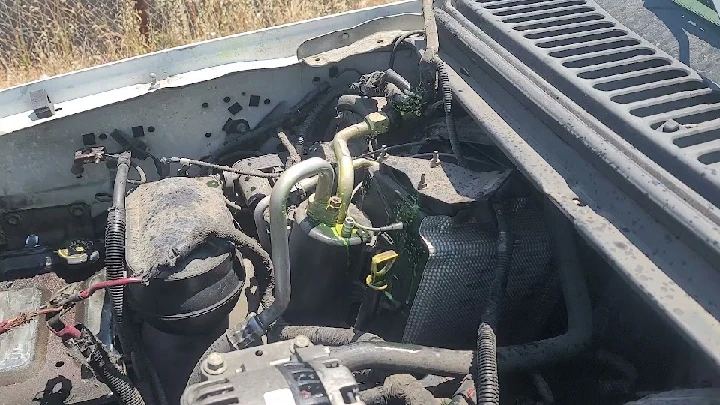 Engine components viewed from above, dusty and worn.