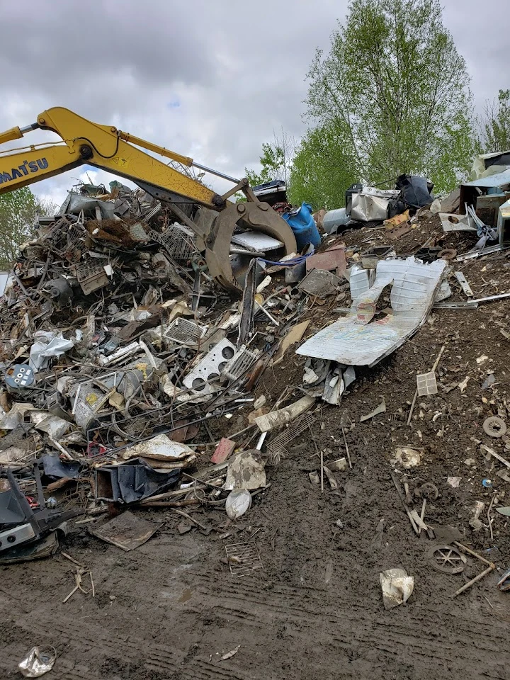 Excavator sorting metal debris at a recycling center.