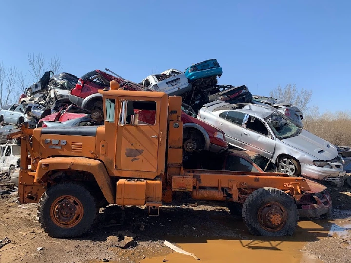 Junked cars piled on a salvage tow truck.