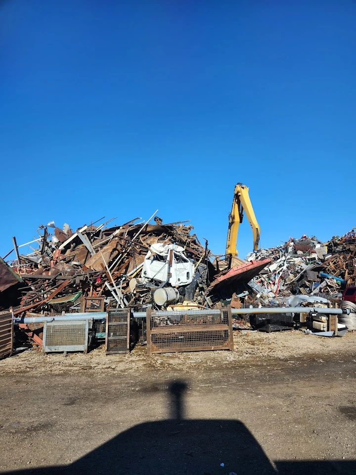 Junkyard with piles of scrap metal and machinery.